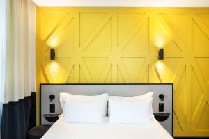 Una cama o camas en una habitación de Logis Hotel Darcy Dijon Centre