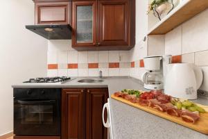 a kitchen with a cutting board of fruit on a counter at Apartments ADELA in Polje