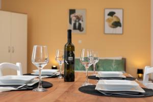 a bottle of wine sitting on a table with glasses at Apartments ADELA in Polje