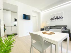 biała jadalnia z białym stołem i krzesłami w obiekcie CARDANO SUITE - 5 min from Central Station w Mediolanie