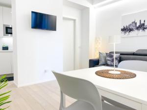 Biały salon z białym stołem i krzesłami w obiekcie CARDANO SUITE - 5 min from Central Station w Mediolanie