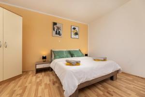 a bedroom with a large white bed with green pillows at Apartments ADELA in Polje