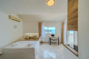 a bedroom with a bed and a desk and a table at Villa LeMar in Baška Voda