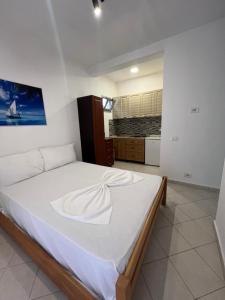 a bedroom with a large white bed in a room at Hotel PEJA in Velipojë