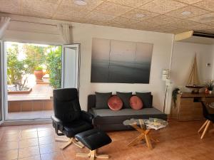 een woonkamer met een bank en twee stoelen bij Apartamento Nuria,Centro del Pueblo,Planta baja con jardin, Aire Acondicionado in L'Escala