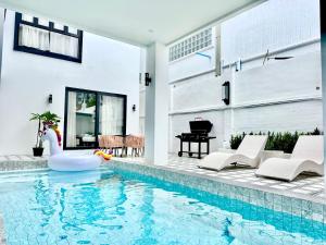 ein Schwimmbad mit Schwan in einem Haus in der Unterkunft Sun Sky Villa 6 Bed Pool BBQ KTV Group Friendly - 7 in Pattaya South