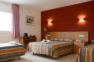 a hotel room with two beds and a desk at Hotel Europa de Figueres in Figueres