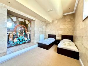a room with two beds and a painting on the wall at NEW BELLA HOTEL in Yerevan +121 photos