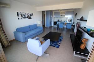 sala de estar con sofá azul y mesa en Atlantico Apartments, en Portimão