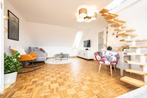 a living room with wooden floors and a spiral staircase at Altstadt Auszeit in Freiburg im Breisgau