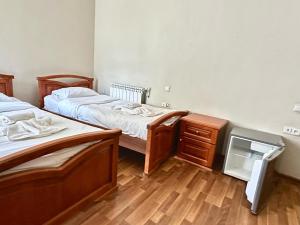 a room with two beds and a dresser in it at NEW BELLA HOTEL in Yerevan