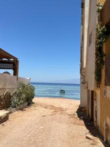 a beach with a boat in the water w obiekcie A bohemian-style studio in dahab w mieście Dahab +5 zdjęć