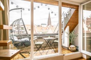 a balcony with a swing and a view of the city at Altstadt Auszeit in Freiburg im Breisgau