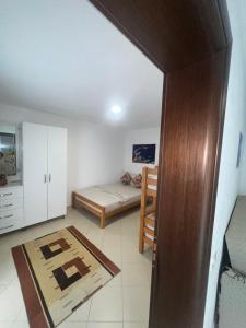 a small room with a bed and a table at Hotel PEJA in Velipojë