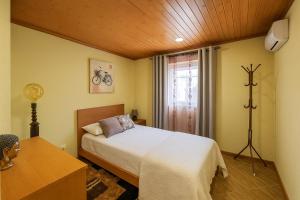 a bedroom with a bed and a table and a window at Casa Madureira - Paraíso centenário do Douro in Sabrosa