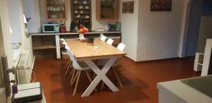 a kitchen with a wooden table and white chairs at Großer Stern in Stoltebüll