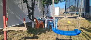 a swing with chairs and a table and a table at Casa Geo in Vadu