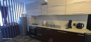 a kitchen with a sink and a refrigerator at Divine place Pomorie in Pomorie