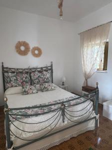 a bedroom with a metal bed with flowers on it at Trullo Monticello in Martina Franca +25 photos
