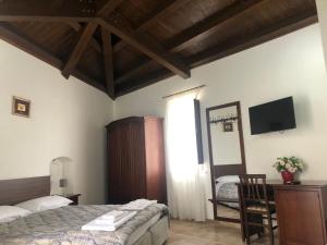 a bedroom with a bed and a desk and a television at Foresteria del Borgo Antico in Ascoli Satriano