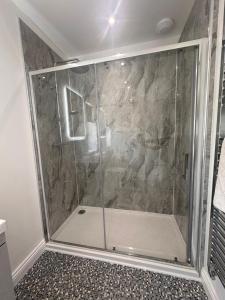 a shower with a glass door in a bathroom at Lakeside Log Cabin in Legbourne +9 photos