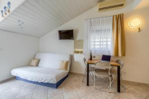 a bedroom with a bed and a table with a laptop at Villa LeMar in Baška Voda