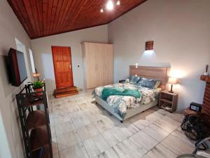 a bedroom with a bed and a wooden ceiling at Sunbird Studio Apartment in Brackenfell