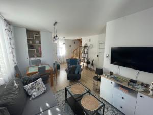 a living room with a couch and a flat screen tv at Sopocka Przystań - domek letniskowy in Ciotusza Stara