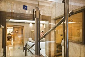 a woman is standing behind a glass door in a room at Hospedium Hotel Los Condes in Madrid