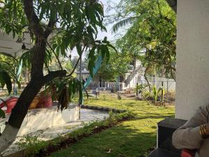 un albero in un cortile accanto a una casa di Malhar Baug Resort a Nagaon