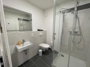 a bathroom with a shower and a toilet and a sink at Appartementhaus Strausberg-Nord in Strausberg