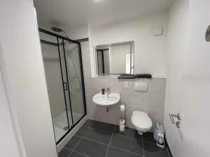 a bathroom with a shower and a toilet and a sink at Appartementhaus Strausberg-Nord in Strausberg
