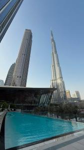 a large pool of water in front of tall buildings at Luxury 2BR Sea View Walk to Burj & Dubai Mall in Dubai