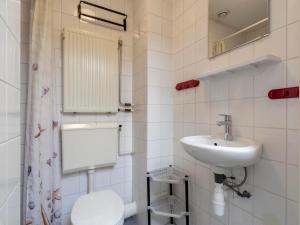 a white bathroom with a sink and a toilet at Villa in Julianadorp near Sandy Beach in Julianadorp +18 photos
