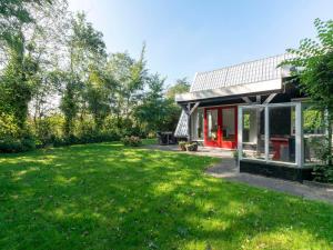 a house with a large yard in front of it at Villa in Groote Keeten near Stunning Beach in Callantsoog