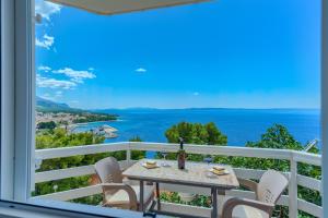 a table and chairs on a balcony with a view of the ocean at Villa LeMar in Baška Voda
