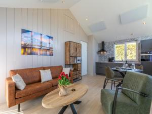 a living room with a couch and a table at Wellness Home by Dutch Coast with Sauna in De Zandloper