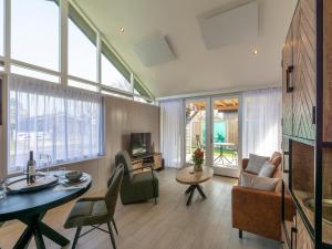a living room with a table and chairs and a tv at Wellness Home by Dutch Coast with Sauna in De Zandloper