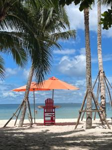 una playa con una silla y una sombrilla y el océano en Herotus Local House near Beach, en Phu Quoc