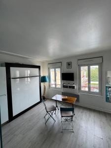a living room with a table and two chairs at Le 27 Deauville in Deauville