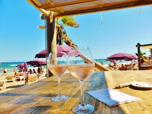 two glasses of wine sitting on a table near the beach at Carazur Mobilhomes Camping Fréjus in Fréjus