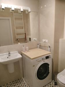 a bathroom with a washing machine and a sink at Quiet in the City Wrocławska in Kraków