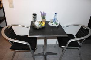 マルメディにあるChez Martineのダイニングテーブル(椅子2脚、黒いテーブル、木製の椅子付)
