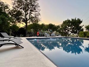 a swimming pool with two chairs and a person in the background at Stunning Property with Private Pool in Cefalù in Cefalù