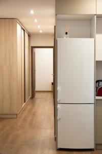 an empty office with a white refrigerator in a hallway at Luxus Apartman in Nyíregyháza +7 photos