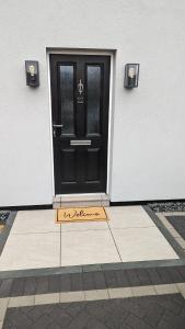 eine Tür mit einer Fußmatte davor in der Unterkunft Modern Gilliver House Rural retreat sleeps 7 in Barlestone