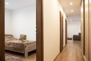 a hallway with a bed and a couch in a room at Luxus Apartman in Nyíregyháza