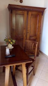 uma mesa de madeira com 2 cadeiras e um armário de madeira em Agriturismo La Chiocciola em Poggio Murella