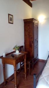 um quarto com uma mesa de madeira e um armário em Agriturismo La Chiocciola em Poggio Murella