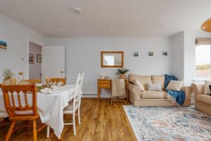 a living room with a table and a couch at Sandy Shores Apartment in Swanage